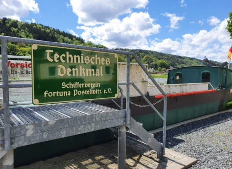 Das Bild zeigt ein altes Schiff mit dem Schild "Technisches Denkmal"